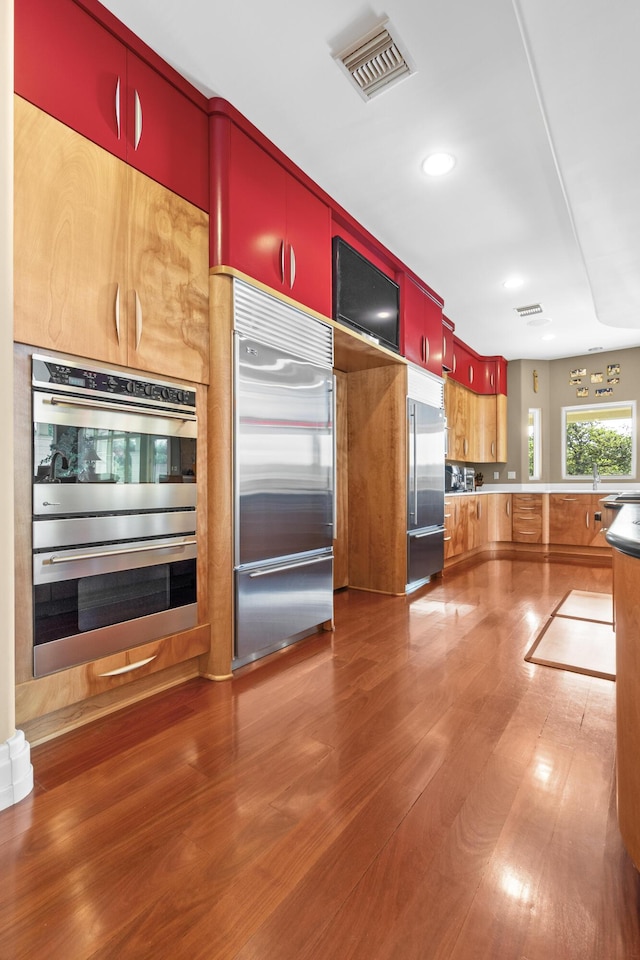 kitchen with appliances with stainless steel finishes, wood finished floors, and recessed lighting