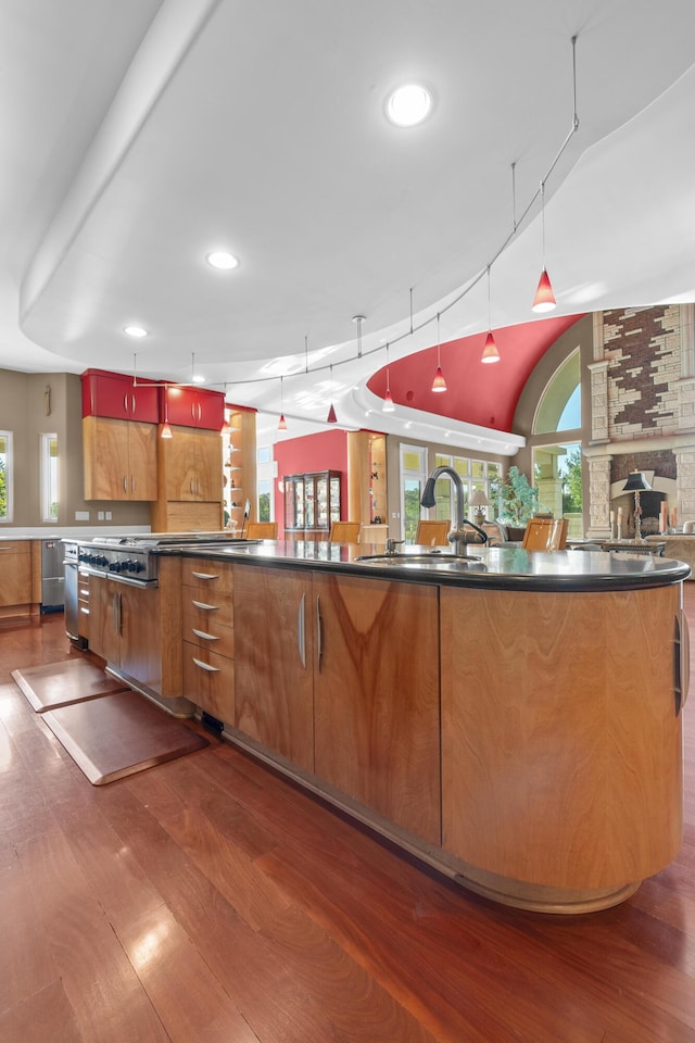 kitchen featuring a sink, hardwood / wood-style flooring, dark countertops, plenty of natural light, and recessed lighting