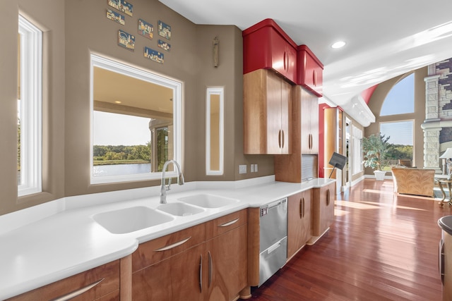 kitchen featuring dishwasher, dark wood-type flooring, a sink, light countertops, and recessed lighting