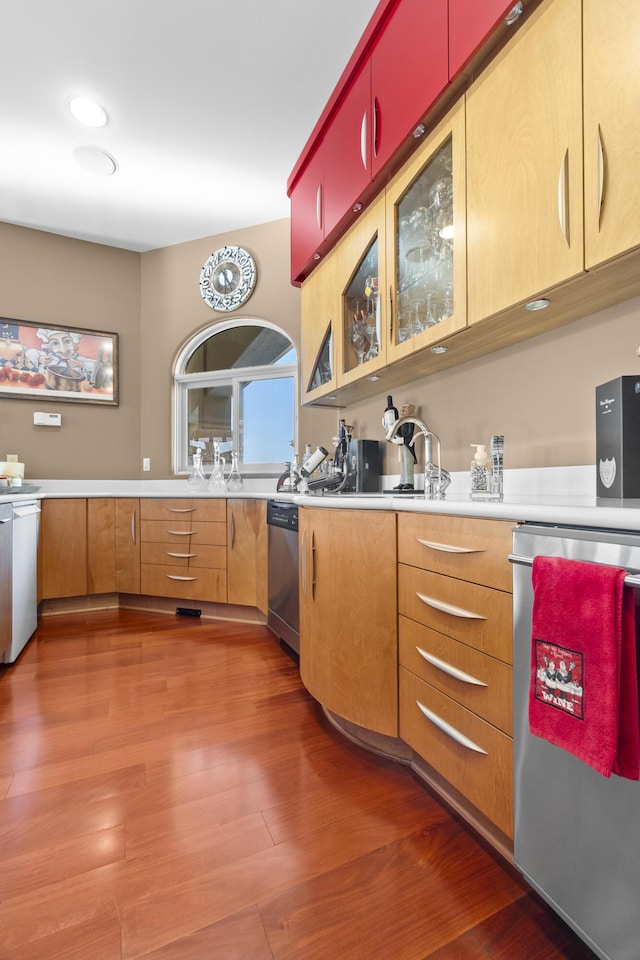 kitchen with dishwasher, light countertops, and wood finished floors