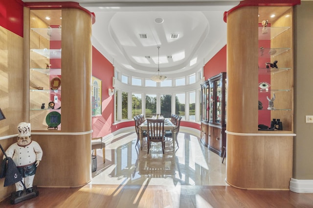 dining room featuring a tray ceiling, baseboards, and wood finished floors