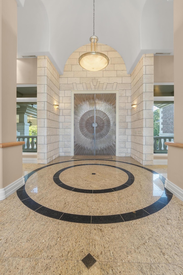 entryway with inlaid floor details, granite tiled floors, baseboards, and a fireplace