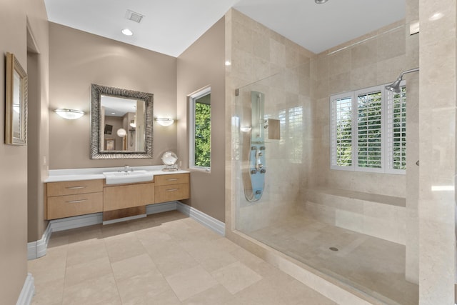 bathroom with a shower stall, plenty of natural light, baseboards, and vanity