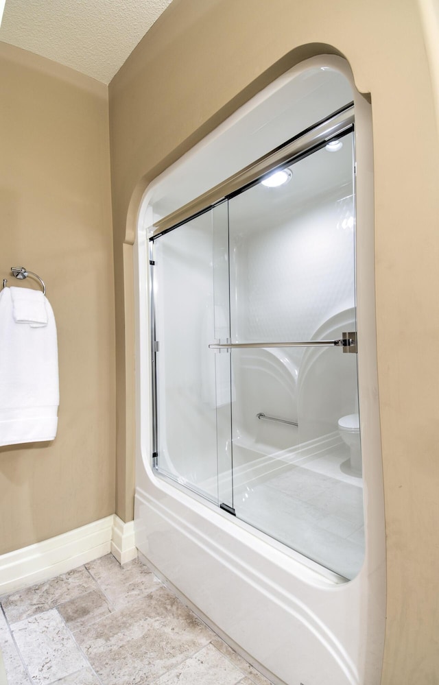 full bath with baseboards and an enclosed shower