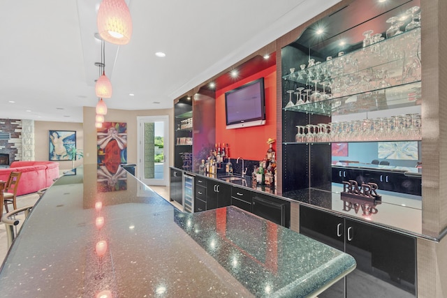 indoor wet bar featuring wine cooler and pendant lighting