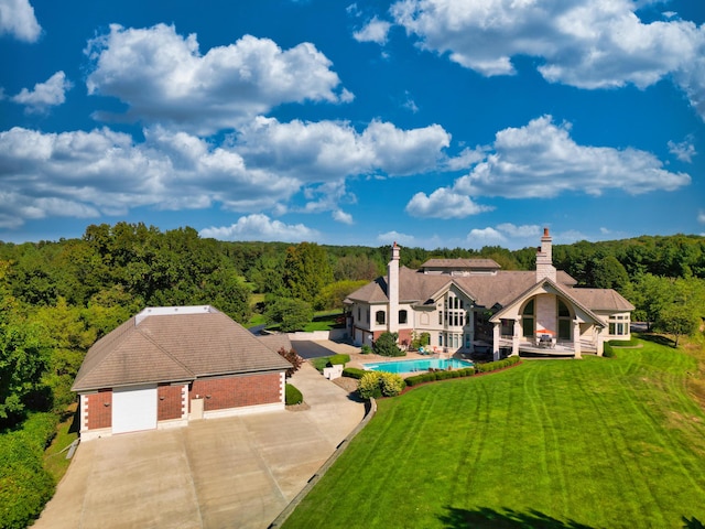view of subject property with a heavily wooded area and a pool area