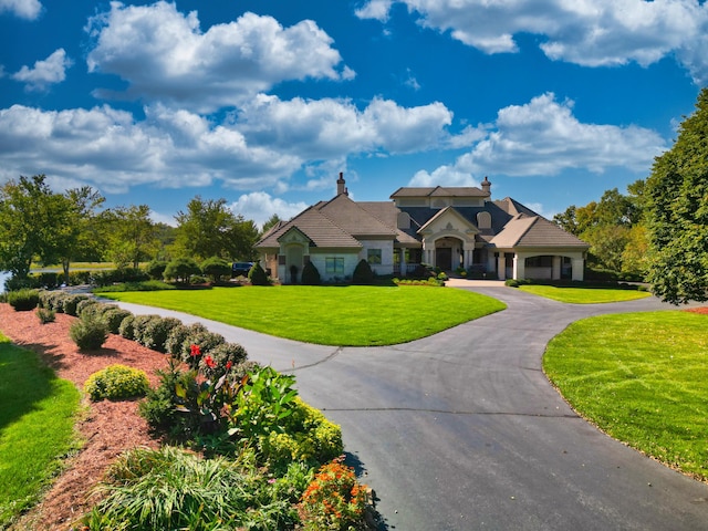 french provincial home with curved driveway and a front yard