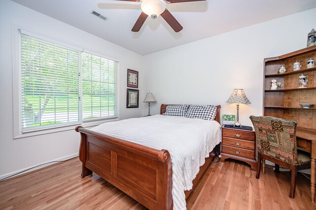 bedroom with light wood-style flooring, ceiling fan, and baseboards