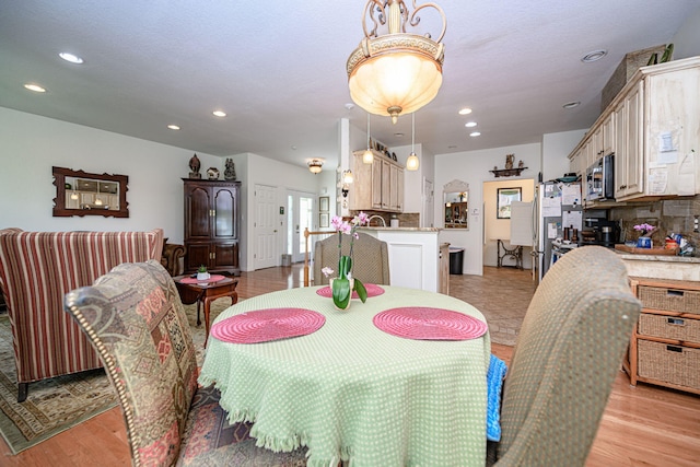 dining space featuring recessed lighting and light wood finished floors