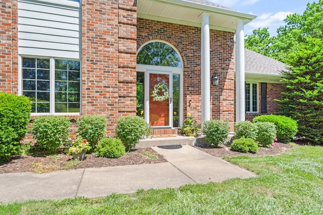 4700 E Deer Noll Rd, Columbia, MO 65201 - view of exterior entry with brick siding, a shingled roof, and a lawn
