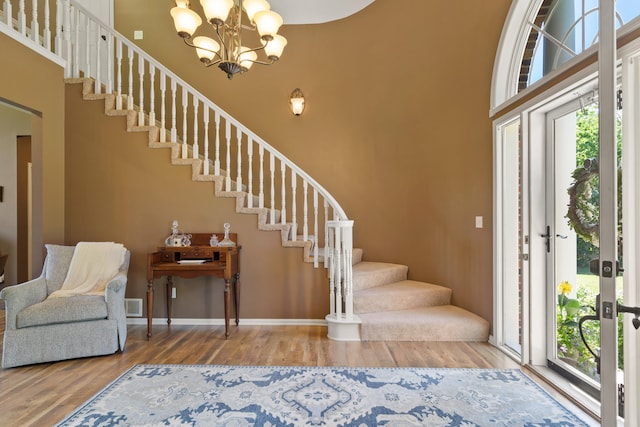 4700 E Deer Noll Rd, Columbia, MO 65201 - foyer entrance featuring stairs, wood finished floors, a high ceiling, a chandelier, and baseboards