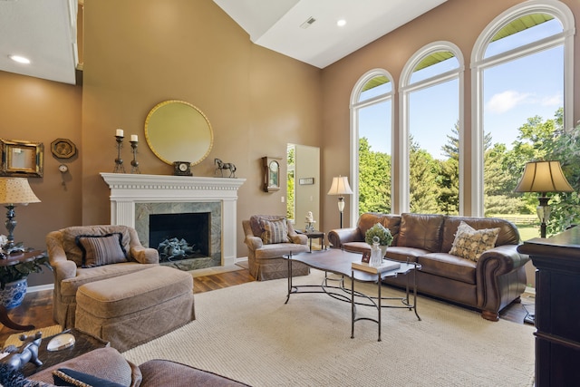 4700 E Deer Noll Rd, Columbia, MO 65201 - living room with high vaulted ceiling, wood finished floors, a high end fireplace, baseboards, and recessed lighting
