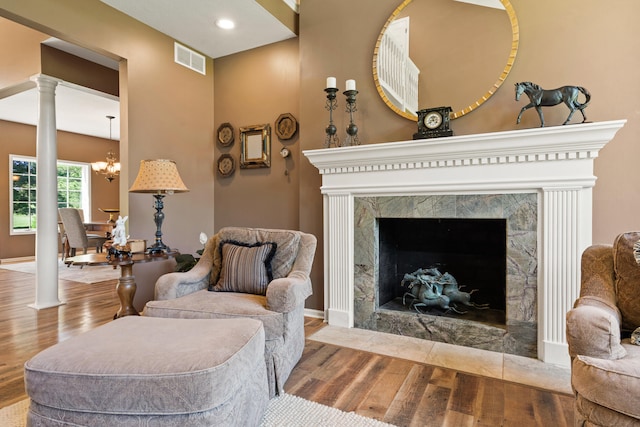 4700 E Deer Noll Rd, Columbia, MO 65201 - living area with wood finished floors, a chandelier, ornate columns, baseboards, and recessed lighting