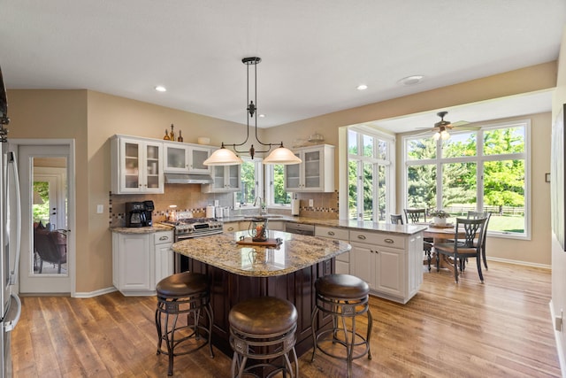 4700 E Deer Noll Rd, Columbia, MO 65201 - kitchen with a center island, stainless steel appliances, under cabinet range hood, light wood finished floors, and recessed lighting