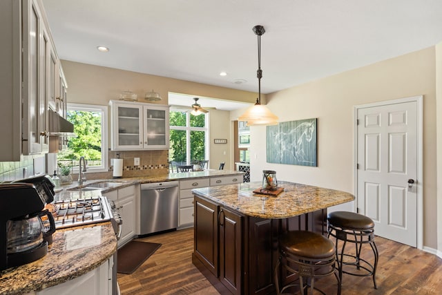 4700 E Deer Noll Rd, Columbia, MO 65201 - kitchen with dishwasher, a sink, a breakfast bar area, decorative backsplash, and dark wood-style flooring
