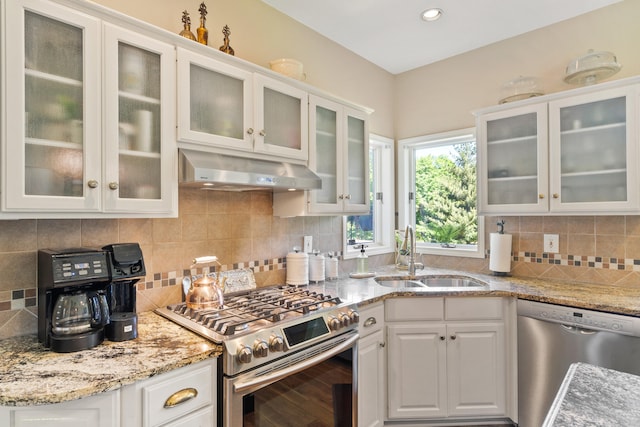 4700 E Deer Noll Rd, Columbia, MO 65201 - kitchen featuring stainless steel appliances, under cabinet range hood, a sink, tasteful backsplash, and white cabinets