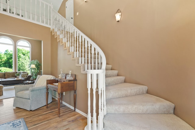 4700 E Deer Noll Rd, Columbia, MO 65201 - stairs featuring wood finished floors, a towering ceiling, and baseboards