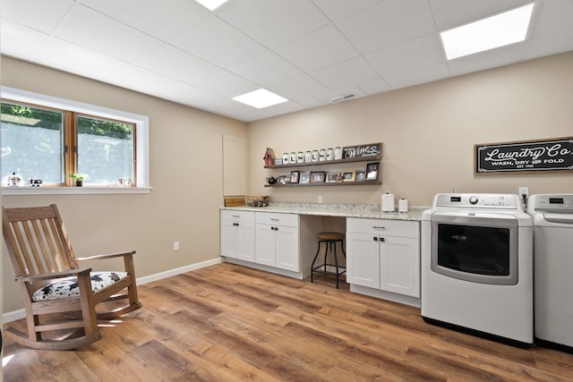 4700 E Deer Noll Rd, Columbia, MO 65201 - laundry room featuring washer and clothes dryer, light wood-type flooring, cabinet space, and baseboards