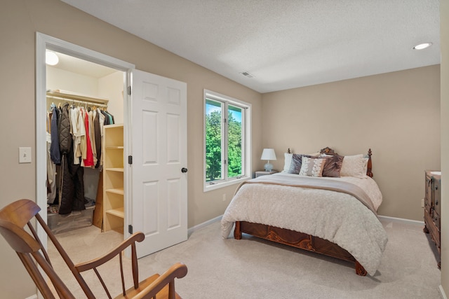 4700 E Deer Noll Rd, Columbia, MO 65201 - bedroom featuring light carpet, a walk in closet, baseboards, a closet, and a textured ceiling
