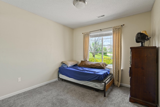 carpeted bedroom featuring baseboards and a textured ceiling