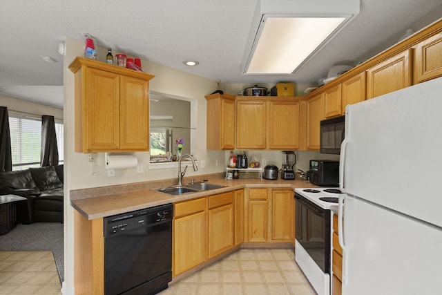 kitchen with black appliances, a sink, light flooring, healthy amount of natural light, and recessed lighting