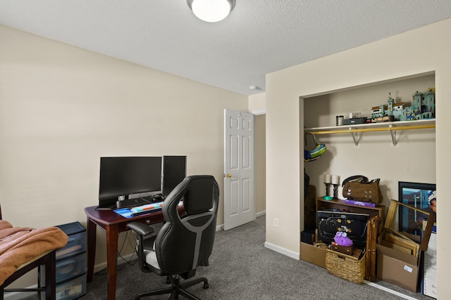 carpeted office with baseboards and a textured ceiling