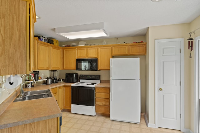 kitchen with black microwave, freestanding refrigerator, electric range, a sink, and light countertops