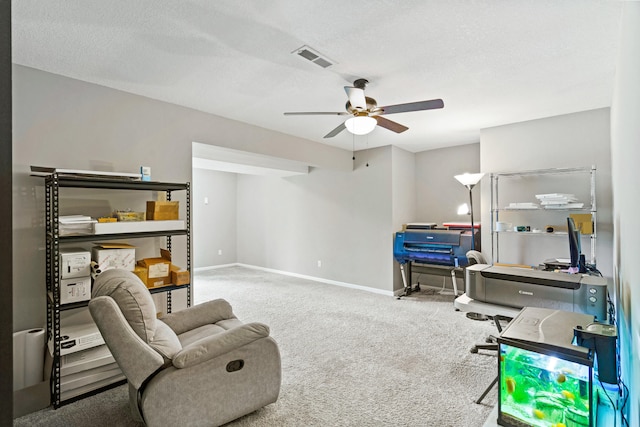 sitting room featuring carpet, ceiling fan, baseboards, and a textured ceiling