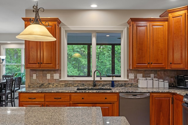 kitchen featuring dishwasher, a sink, dark stone counters, backsplash, and recessed lighting