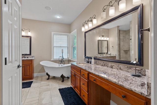 full bath featuring a freestanding tub, vanity, baseboards, and tiled shower