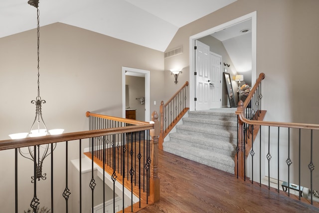 stairway featuring lofted ceiling and wood finished floors