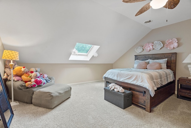 bedroom with carpet, vaulted ceiling, a skylight, ceiling fan, and baseboards