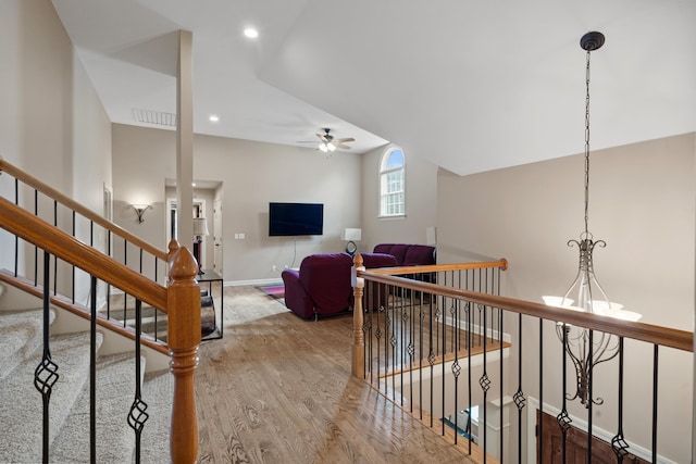 hall featuring wood finished floors, baseboards, recessed lighting, and an upstairs landing