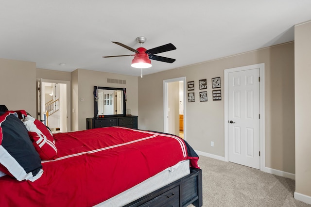 bedroom with light colored carpet, baseboards, ensuite bathroom, and ceiling fan