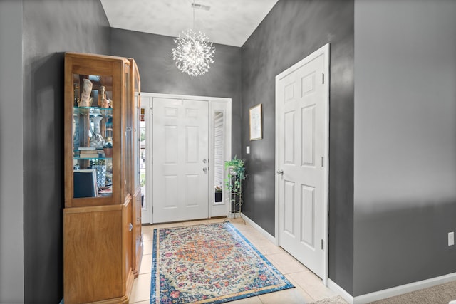 entrance foyer featuring light tile patterned flooring, a chandelier, and baseboards