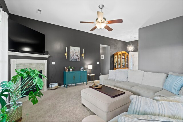 living room with light carpet, a ceiling fan, a fireplace, and baseboards