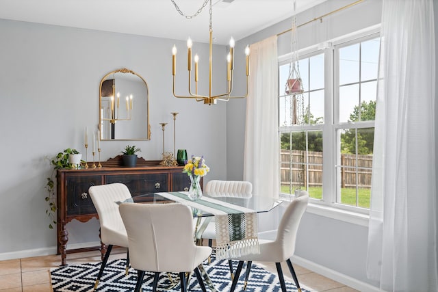 tiled dining space featuring a chandelier and baseboards