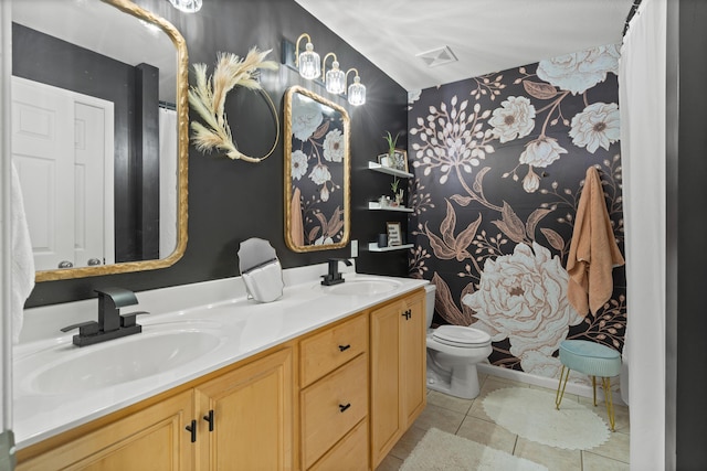 bathroom featuring tile patterned flooring, toilet, and double vanity