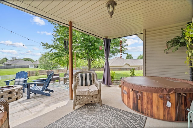 view of patio / terrace featuring a hot tub, an outdoor fire pit, and a fenced backyard