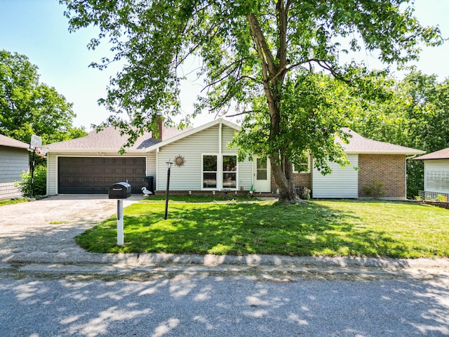 view of front facade featuring a front yard, a chimney, driveway, brick siding, and a garage