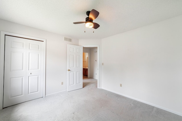 unfurnished bedroom with light carpet, baseboards, a closet, and ceiling fan