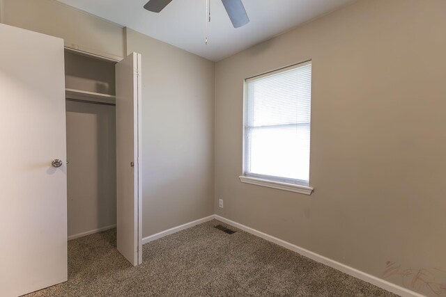 unfurnished bedroom featuring carpet flooring, a closet, baseboards, and a ceiling fan