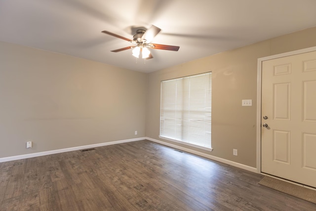 empty room featuring ceiling fan, baseboards, and dark wood-style floors