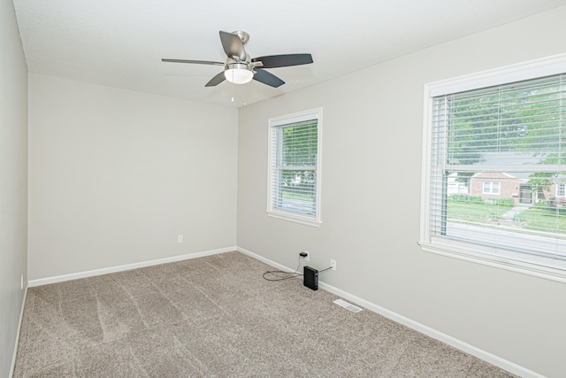 spare room featuring carpet floors, baseboards, and a ceiling fan