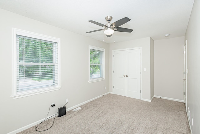 unfurnished bedroom with a closet, baseboards, carpet floors, and ceiling fan