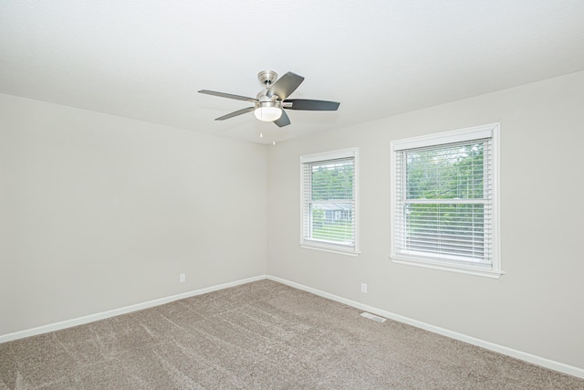 spare room featuring baseboards, a ceiling fan, and carpet