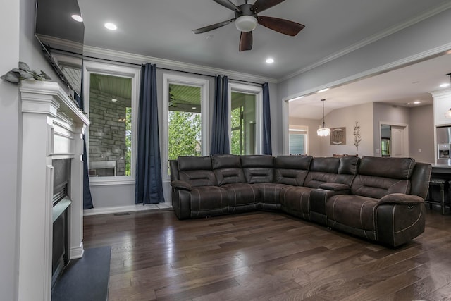 living room with a fireplace, dark wood-style floors, a ceiling fan, ornamental molding, and baseboards