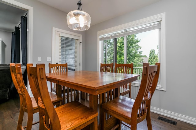dining room featuring dark wood-style flooring and baseboards
