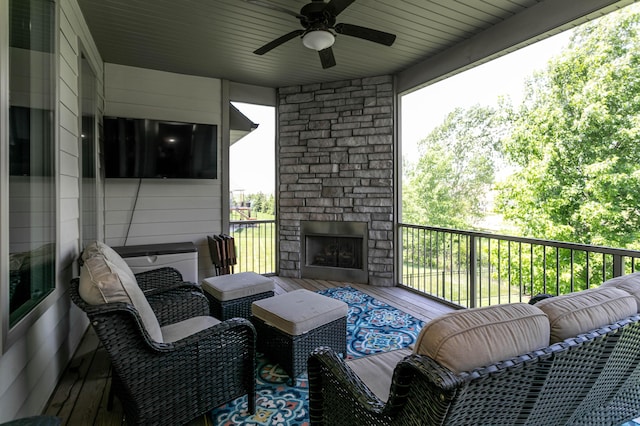 view of patio with an outdoor stone fireplace and ceiling fan