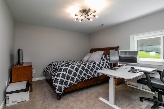 carpeted bedroom featuring baseboards and a desk